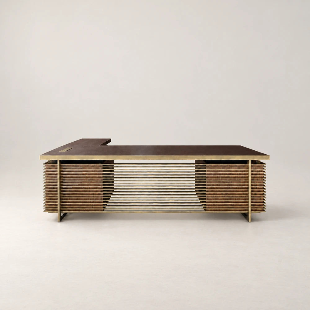 Front view of the DK02 Desk by Eva Szumilas, with a dark L-shaped desktop, gold-toned frame and horizontal bars spanning two wooden pedestals.